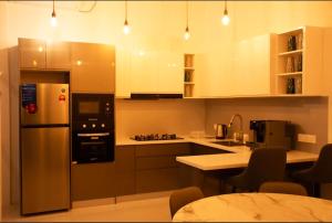 a kitchen with a stainless steel refrigerator and a table at Sunset Private Villa in Bandara