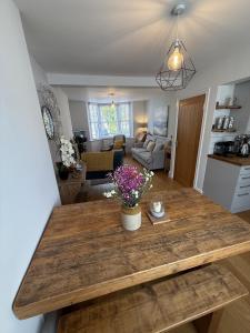 a kitchen and living room with a table with flowers on it at Highfield Terrace – Cosy Devon Retreat, Close to Beer Beach in Beer