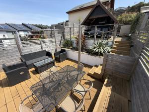 a patio with a table and chairs on a deck at Highfield Terrace – Cosy Devon Retreat, Close to Beer Beach in Beer