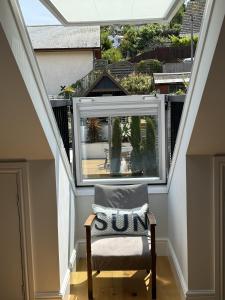 an attic room with a window and a chair at Highfield Terrace – Cosy Devon Retreat, Close to Beer Beach in Beer +26 photos