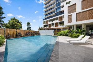 an image of a swimming pool in front of a building at Alcyone at The Corso in Maroochydore