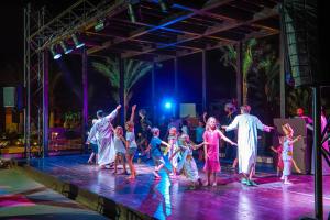 een groep kinderen die dansen op het podium tijdens een concert bij Jaz Makadi Oasis Resort in Hurghada
