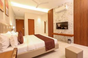 a hotel room with a bed and a television at HOTEL NARMADA RESIDENCY in Maheshwar