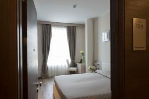 a hotel room with a bed and a window at Expo Hotel Milan in Parabiago