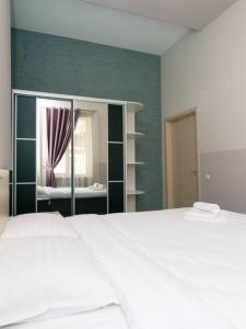 una camera da letto con un grande letto bianco e uno specchio di Apartment near Olympic stadium a Kiev