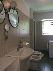 a bathroom with a sink and a toilet and a mirror at Apartments Alpha Center in Bovec