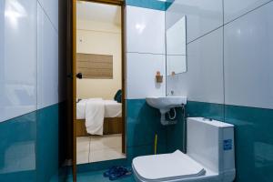 a bathroom with a toilet and a sink and a mirror at Hotel Aeronest Residency in Calicut +48 photos