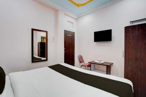 a bedroom with a bed and a table and a mirror at Super Collection O Patna Airport Formerly Hotel Shahi Mahal in Dānāpur