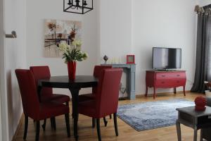 uma sala de jantar com mesa e cadeiras e uma televisão em Leon Suite Apartments em Leipzig