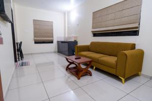 a living room with a couch and a coffee table at Hotel Aeronest Residency in Calicut