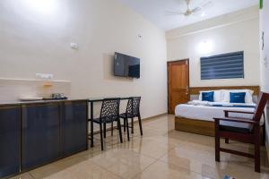a hotel room with a bed and a desk and chairs at Hotel Aeronest Residency in Calicut