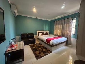 a bedroom with a bed and a couch and a window at Chareli Resort in Nagarkot