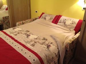 a bed with a white comforter on it at Appartamento Chappelette in Breuil-Cervinia