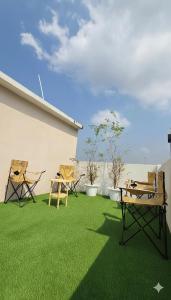 a patio with chairs and a table and grass at Zanit Hostel in Don Muang Airport