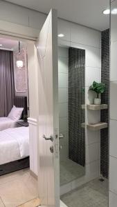 a bathroom with a shower with a bed and a glass door at برج داماك الجوهرة جدة - Damac al jawharah tower in Jeddah +80 photos