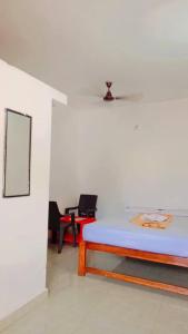 a room with a bed and a table and chairs at Krishna Guest House in Arambol