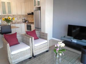 a living room with two chairs and a television at 308 St Tropez in Strand