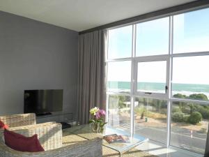 uma sala de estar com um sofá e uma grande janela em 308 St Tropez em Strand