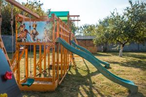 a playground with a slide in a yard at Fermerska Hata in Dubno