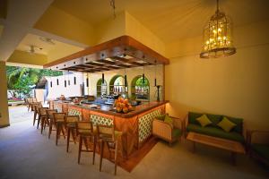 a kitchen with a bar with a bunch of chairs at Kingfisher Beach in Unawatuna
