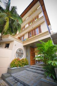 a hotel with a staircase leading to the front door at Kingfisher Beach in Unawatuna