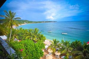 a view of a beach with palm trees and the ocean at Kingfisher Beach in Unawatuna