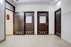 a row of wooden doors in a room at Super Hotel O Dwarka Mor Metro Station in New Delhi