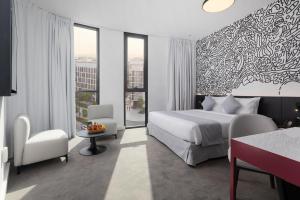 a hotel room with a bed and a table and chairs at Nest Hotel, Aljada in Sharjah
