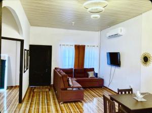 a living room with a couch and a table at Joy & peace house in Tela