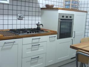 Edvige' S House in Residence في سان فيليس سيرسيو: مطبخ بخزائن بيضاء وفرن موقد