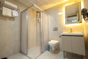 a bathroom with a shower and a toilet and a sink at Dedem Hotel Dinlenme Tesisleri-Sultanhanı in Sultanhanı +27 photos