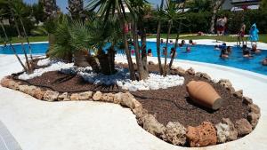 um jardim no meio de uma piscina num resort em Rosie Apartment em Campoamor