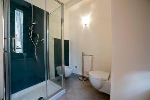 La salle de bains est pourvue d'une douche en verre et de toilettes. dans l'établissement Marghaerita B&B, à Cetraro