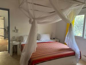 a bedroom with a bed with a canopy at Downtown Malindi Apartment in Malindi