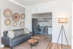 a living room with a couch and a kitchen at 2 on Hope in Simonʼs Town