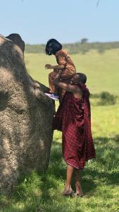 two women standing next to a large rock at Bwana Renman Campsite in Narok