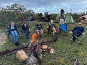 a group of people sitting around a fire at Bwana Renman Campsite in Narok