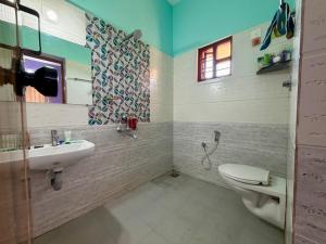 a bathroom with a toilet and a sink at Laksh Nivas Fields Stay in Udupi +10 photos