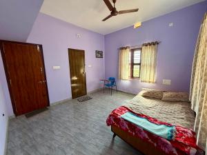 a bedroom with a bed with purple walls and a ceiling at Laksh Nivas Fields Stay in Udupi