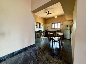 a kitchen with a table and chairs and a ceiling at Laksh Nivas Fields Stay in Udupi