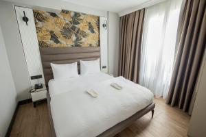 a bedroom with a large white bed with two phones on it at Dedem Hotel Dinlenme Tesisleri-Sultanhanı in Sultanhanı