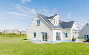 a white house with a blue roof at Portbeg Holiday Homes at Donegal Bay in Bundoran