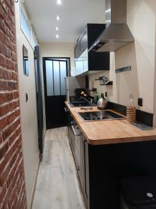 a kitchen with a counter and a brick wall at Duplex 4 Personnes 5 Minutes a pied du petit port et 10 Minutes de la plage in Le Havre