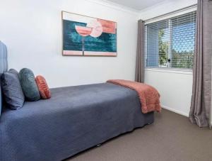 a bedroom with a blue bed and a window at House 4-bed 2-bath Caboolture South in Caboolture