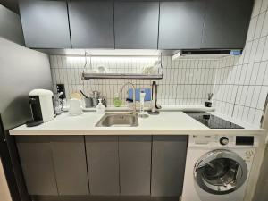 a kitchen with a sink and a washing machine at 샤인 스테이 in Kung-mal