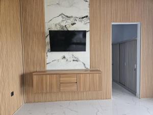 a living room with a tv on a wall at Arkana Homestay in Tabanan