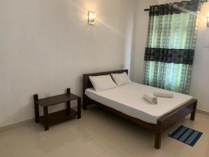 a small bedroom with a bed and a table at New Papa Palace in Wattegama +18 photos