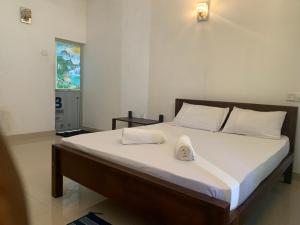a bedroom with a large bed with two towels on it at New Papa Palace in Wattegama