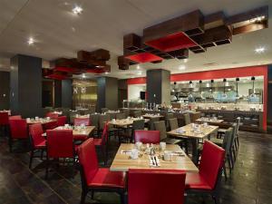 a restaurant with wooden tables and red chairs at Hyatt Regency Cincinnati in Cincinnati