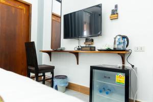 a living room with a tv and a chair at Oudomsin Guesthouse in Luang Prabang
